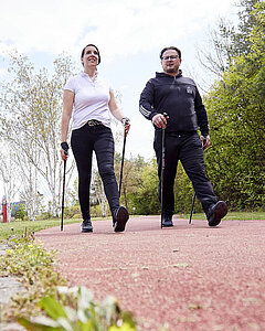 Zwei Personen beim Nordic Walking.